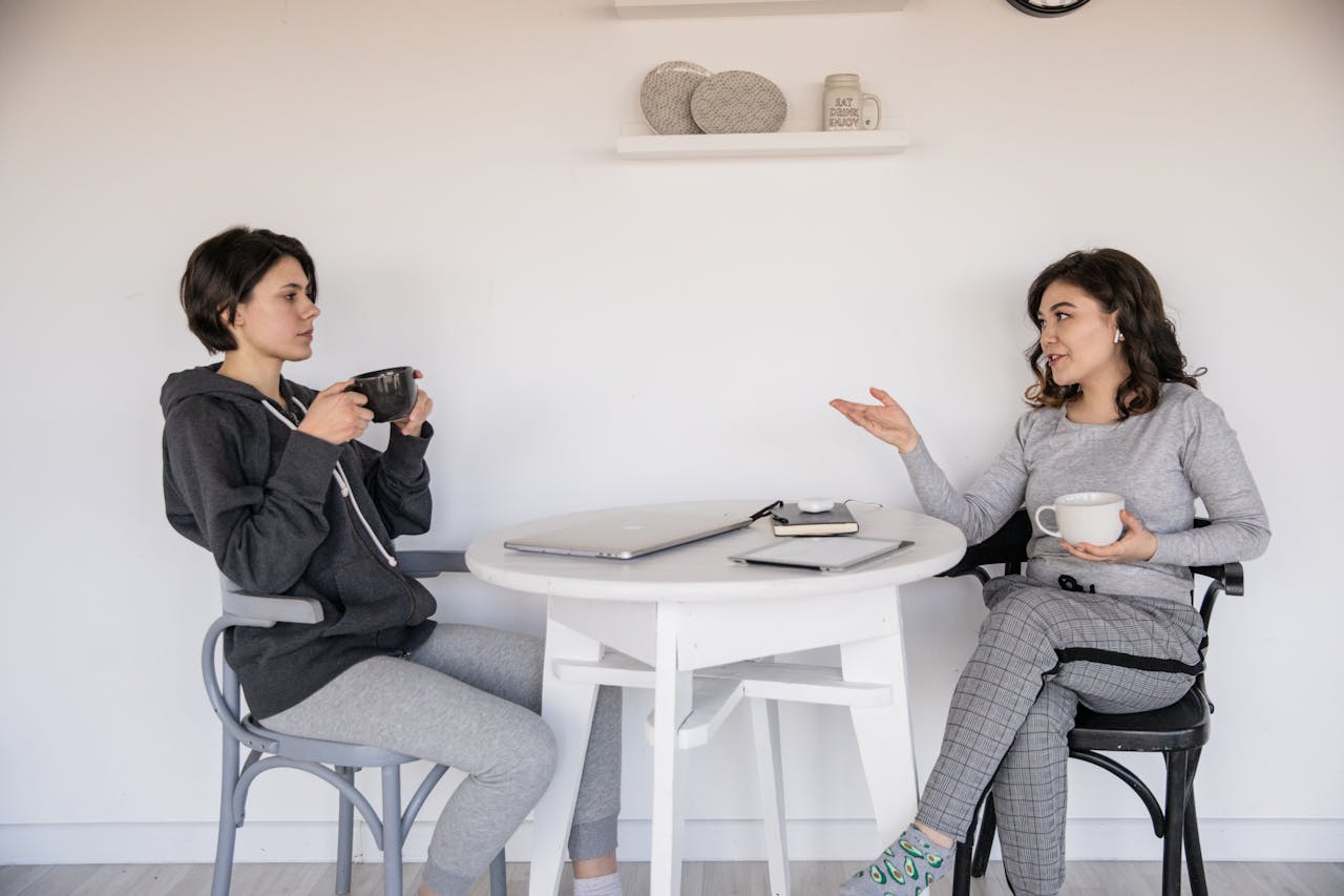 2 women sitting at a table having a conversation