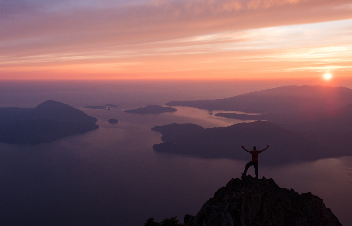 person standing at peak of mountain