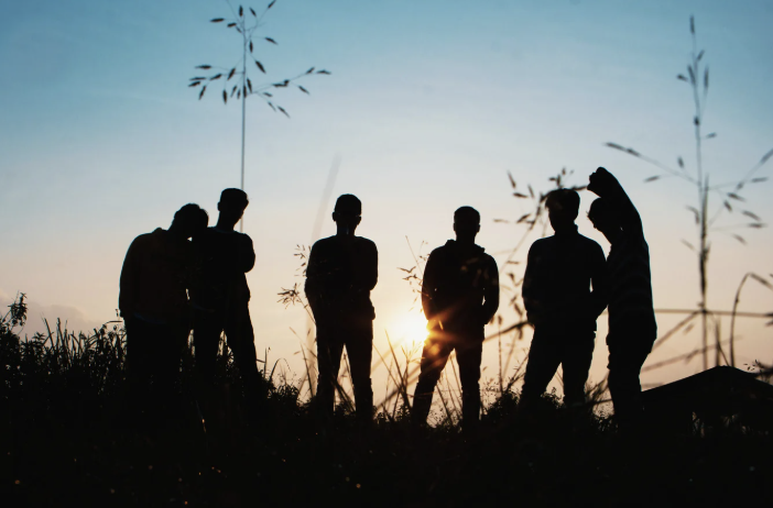 silhouette of six people watching the sunset