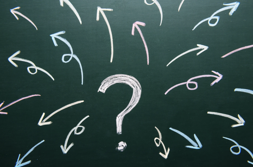 question mark surrounded by arrows drawn on chalkboard