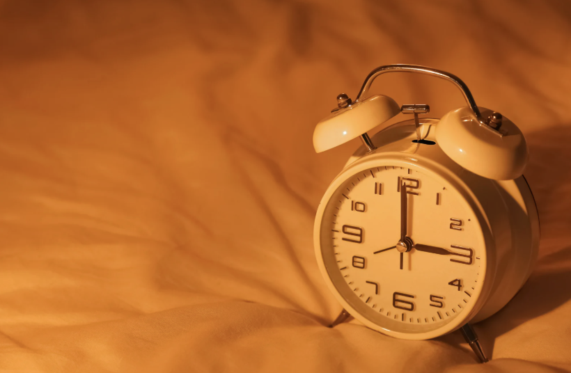 a clock sitting on a bed