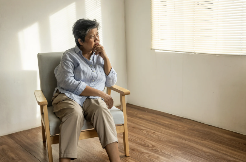 woman sitting in chair in empty room