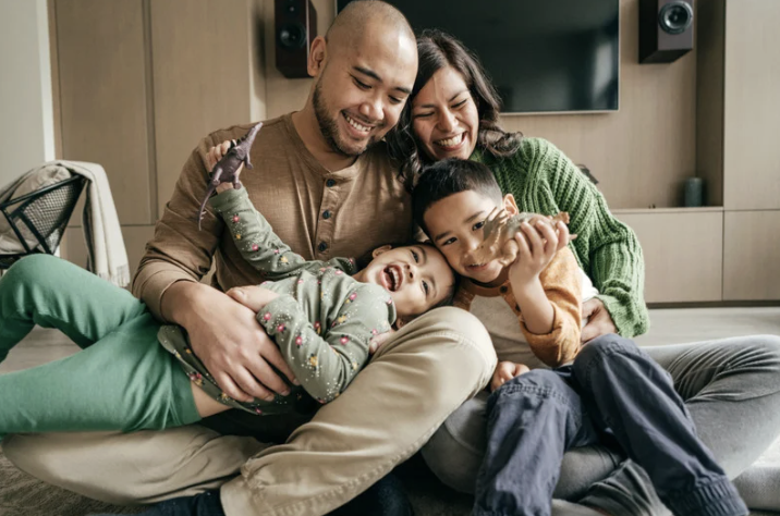 father, mother, and two children laughing together
