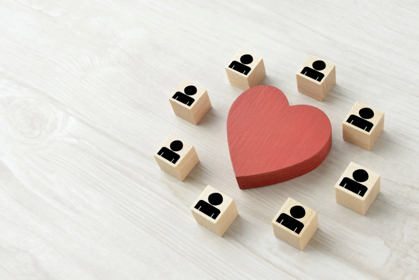 wooden heart surrounded by wooden people icons