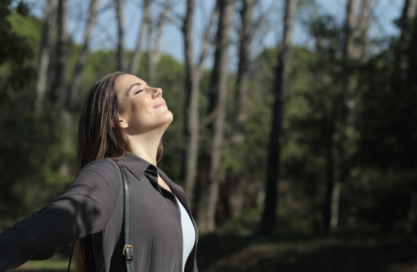 woman standing in nature with outstretched arms